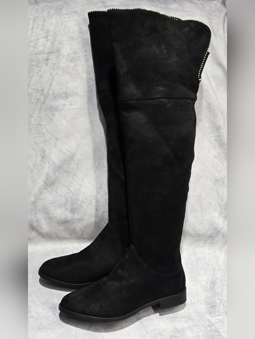 black over-the-knee flat boots in a soft suede-like material with a rounded toe